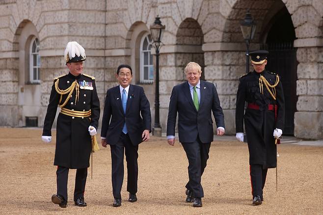 보리스 존슨(오른쪽에서 둘째) 영국 총리와 기시다 후미오(왼쪽 둘째) 일본 총리가 5일(현지 시각) 영국 런던 웨스트민스터에서 열린 환영식에 참석해 나란히 걷고 있다. 두 나라 정상은 이날 회담에서 상대국 영토에 입국하는 군인의 비자 면제 조치 등을 담은 ‘원활화 협정’에 합의했다./로이터 뉴스1
