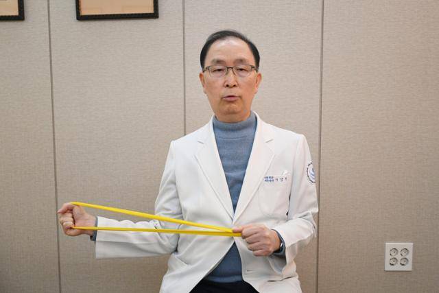 고무밴드 잡고 당기기 자세다. 스포츠재활전문의인 나영무 솔병원 원장이 11월 30일 서울 강서구 솔병원에서 '백세 운동' 시범을 보이고 있다. 윤서영 인턴기자