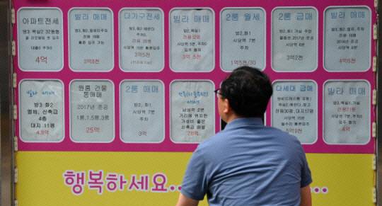 한 서울 시민이 공인중개사 사무소 앞에 붙은 매물 게시물을 살펴보고 있다. 문호남 기자