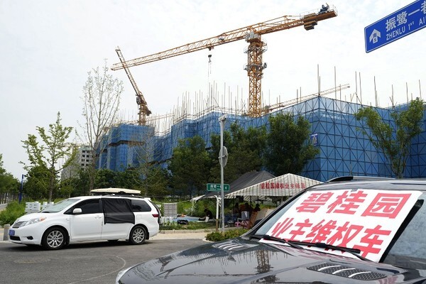 중국 최대 부동산 회사인 컨트리가든의 베이징 공사 현장에 시위 차량이 주차돼 있다. [사진=뉴시스]