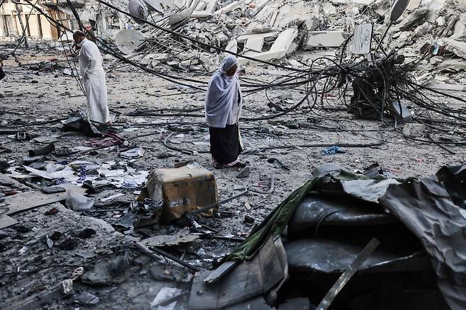 13일 팔레스타인 주민이 이스라엘군의 공격으로 파괴된 가자지구의 건물 잔해를 지나가고 있다. /AP 연합뉴스