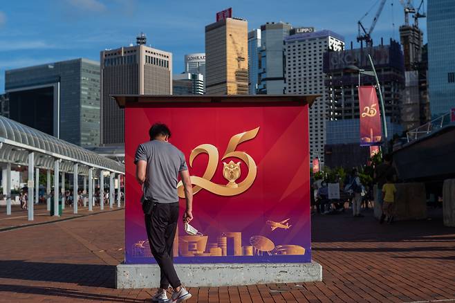 26일 한 남성이 홍콩반환 25주년을 축하하는 포스터앞을 지나가고 있다./EPA 연합뉴스