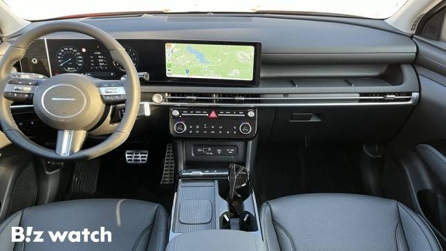 더 뉴 투싼 1열. 이번 부분변경 모델을 통해 12.3인치 파노라믹 커브드 디스플레이가 탑재됐다. 인포테인먼트 시스템은 2개의 다이얼 노브와 8개의 버튼으로 편리하게 조작할 수 있다. 기존 변속 버튼의 자리에는 스마트폰 무선충전 트레이를 마련해 편의성을 더했다./사진=정민주기자