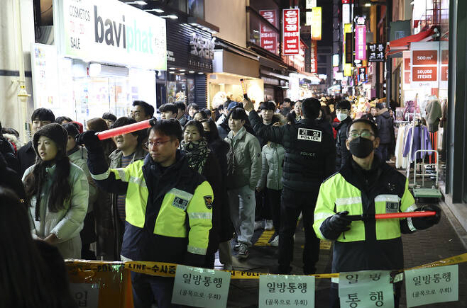 크리스마스 이브인 24일 저녁 경찰이 서울 명동 골목에서 인파를 통제하고 있다. [사진출처 = 연합뉴스]