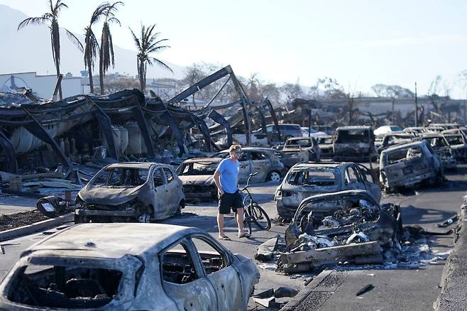 8월 11일(현지 시각) 하와이 마우이섬 라하이나에서 한 남성이 산불 잔해 속을 걷고 있다. 하와이 마우이에서 역사적인 마을을 전멸시킨 산불로 사람들이 목숨을 걸고 도망 치기 전에 경고 사이렌이 울리지 않은 것으로 드러나고 있다./AP 연합뉴스