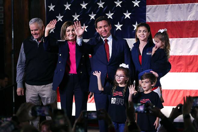 론 디샌티스 플로리다 주지사(왼쪽에서 세번째)가 지난 11월 6일(현지 시각) 아이오와주 디모인의 한 유세에서 손을 흔들어 인사를 하고 있다. 디샌티스 주지사 오른쪽은 배우자 케이시 디샌티스 여사고 왼쪽은 공화당 대선 경선에서 디샌티스 지지를 선언한 킴 레이놀즈 아이오와 주지사다. /AFP 연합뉴스