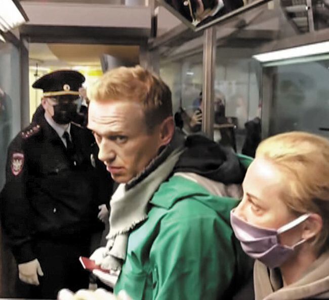 러시아 야권 지도자인 알렉세이 나발니(가운데)가 17일 아내 율리아와 함께 모스크바 공항 입국 심사대에 서 있다. /로이터 연합뉴스
