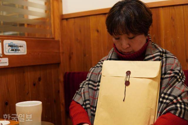 나가누마 마스미가 지난해 11월 29일 상속 관련 서류를 끌어안고 일본 니가타시의 한 카페에 앉아 있다. 박지영 기자