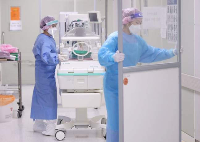 충북대병원과 강원대병원 등 지역 대학병원의 소아과 의료진이 줄사표를 내고 개원가로 옮기면서 지역 의료 붕괴가 가속화하고 있다. 이러한 개원가 이탈 현상은 소아과 등 비인기 진료과에서 안과, 정형외과 등 인기과까지 나타나 고난도·응급 수술을 담당하는 상급종합병원의 위기로 번지고 있다. 사진은 국민건강보험 일산병원에서 신생아를 음압격리병실로 옮기는 모습. 연합뉴스