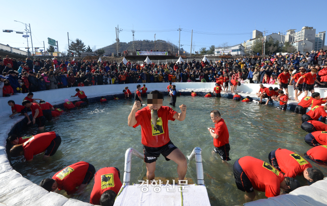 2016년 1월10일 강원 화천군 화천천에서 열린 화천산천어축제에서 한 관광객이 ‘산천어맨손잡기’에 참여해 손으로 잡은 물고기를 입에 물고 있다. 경향신문 자료사진
