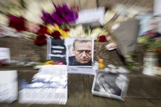 옥중 사망한 러시아 반정부 운동가 알렉세이 나발니의 얼굴 사진이 17일(현지시간) 프랑스 주재 러시아 대사관 벽에 붙어 있다. 시민들은 나발니 사진과 함께 꽃을 올리는 등 추모 행렬이 이어지고 있다. AP 연합뉴스