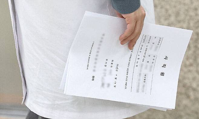 전공의 집단 진료 거부 사태가 임박한 가운데 19일 대구 한 대학병원에서 전공의가 사직원을 들고 있다. 대구=연합뉴스