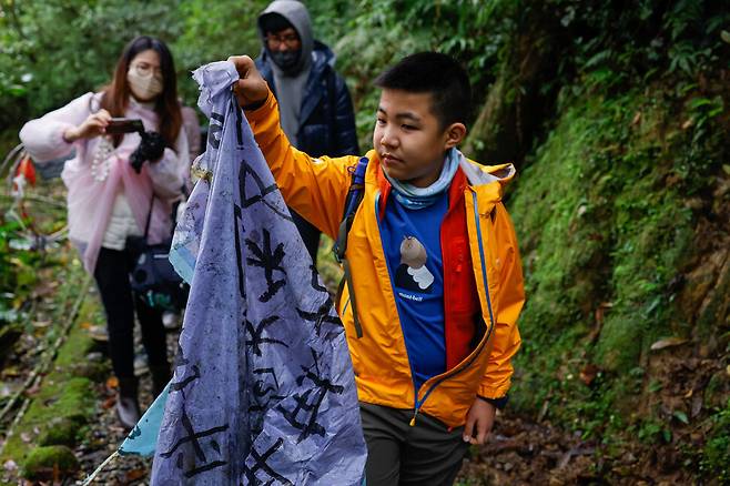 자원봉사자와 학생들이 25일 대만 신베이시 인근에서 나무에 걸린 등의 잔해를 수거하고 있다. 로이터 연합뉴스