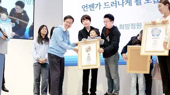 지난해 11월 서울대병원 의생명연구원에서 열린 소아암·희귀질환 극복을 위한 '함께 희망을 열다. 미래를 열다' 심포지엄에서 '희망정원'이란 꽃 도안 전시회에 환아와 가족이 기념사진을 찍고 있다. 사진 서울대병원