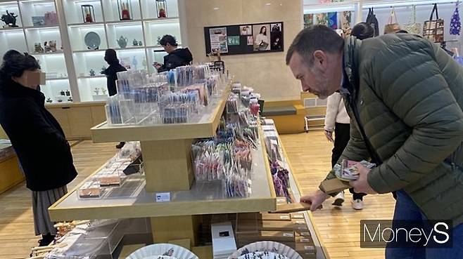 한 외국인이 뮤지업숍에서 뮷즈를 구매하기 위해 진열된 상품을 살피는 모습. /사진=정수현 기자