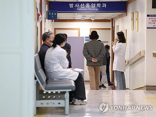 전공의 집단행동이 이어지고 있는 지난 15일 오전 서울 한 대형병원에서 의료진이 환자와 대화를 나누고 있다. 연합뉴스