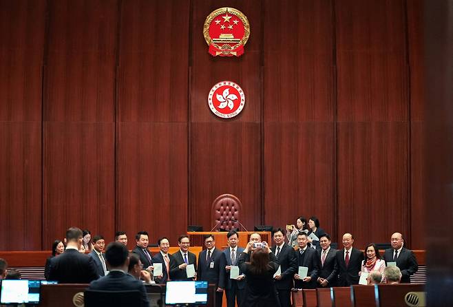 19일 홍콩 입법회에서 크리스 탕(오른쪽에서 아홉째) 보안국장과 의원들이 홍콩판 국가보안법을 들고 기념사진을 찍고 있다. 홍콩/로이터 연합뉴스