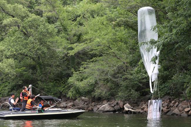 경찰이 2020년 6월23일 탈북단체가 보낸 대북전단 살포용 풍선을 수거하고 있다. 경기 파주에서 보낸 풍선은 강원 홍천군 서면 마곡리 인근 야산에 떨어졌다. 연합뉴스