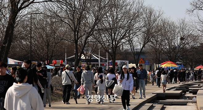 포근한 봄 날씨가 이어진 24일 서울 여의도한강공원을 찾은 시민들이 가벼운 옷차림으로 걷고 있다.