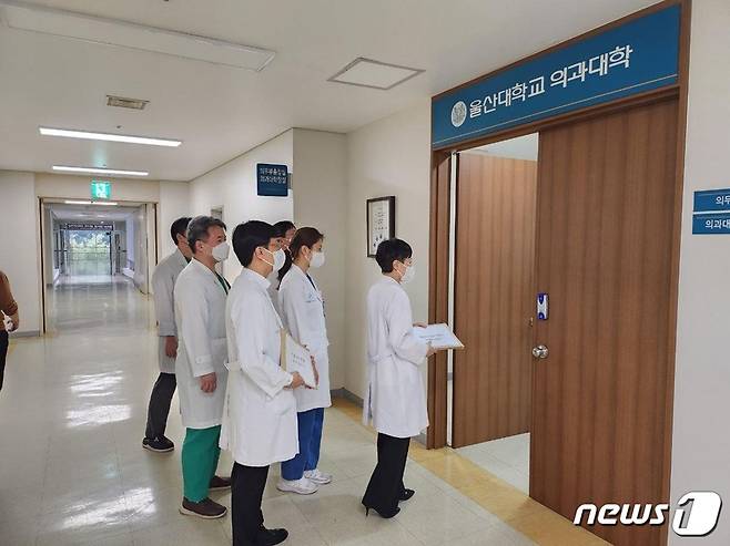 울산대학교 의과대학 교수 비상대책위원회가 25일 울산대 의대 학장실에 사직서를 제출하는 모습(울산대학교 의과대학 교수 비상대책위원회 제공)