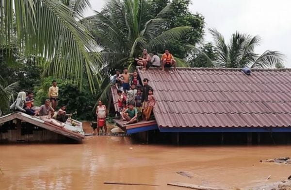 2018년 7월 세피안-세남노이 수력발전소 보조댐 붕괴사고로 인근 마을에서 주민들이 물에 잠긴 가옥 지붕에 대피해 있는 모습./조선DB