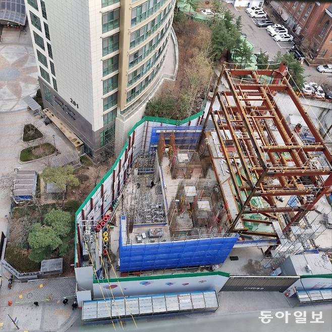 오피스텔(위)과 접한 B 기업 본사 재건축 현장(아래) 모습. 주민들은 오피스텔 건물이 부채처럼 둥글어 상당수 가구의 창문이 새로 짓는 건물의 창문과 마주치는 ‘옆 건물 창문 뷰’ 가 될 것으로 우려하고 있다.