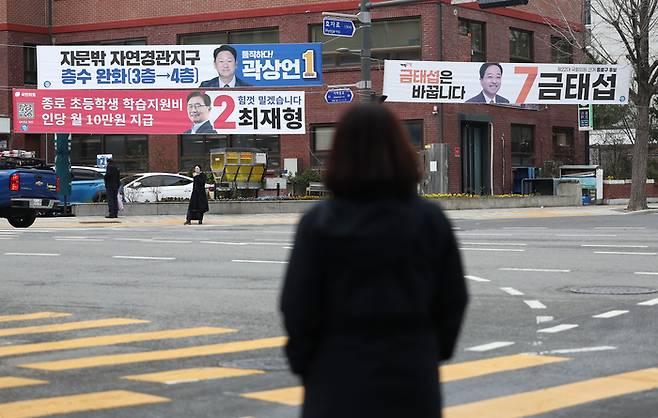22대 국회의원 선거 공식 선거운동이 시작된 28일 한 시민이 서울 종로 청운효자동 주민센터 앞에 걸린 후보들의 홍보 현수막을 보고 있다. 연합뉴스