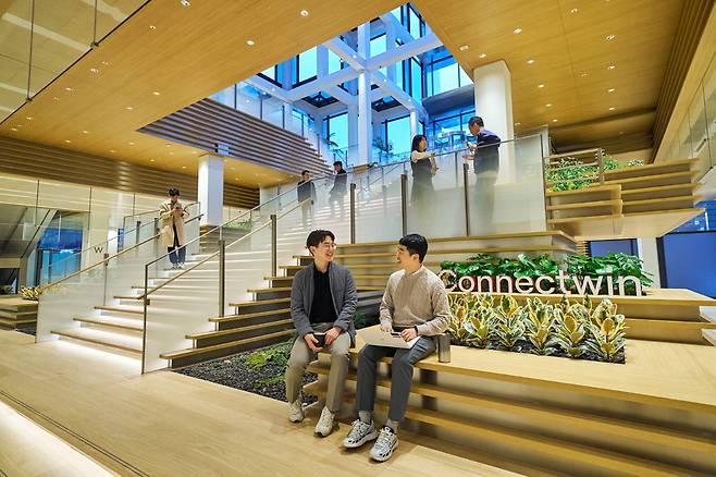 LG는 서울 여의도 LG트윈타워가 1987년 완공된 이후 처음으로 저층부 공용 공간 리모델링을 마치고 다음달 1일 새롭게 선보인다고 28일 밝혔다. 이번 리모델링은 '연결'을 강화하는 데 초점을 맞췄다. LG 직원들이 공용 공간 '커넥트윈'에서 대화를 나누고 있다.  LG