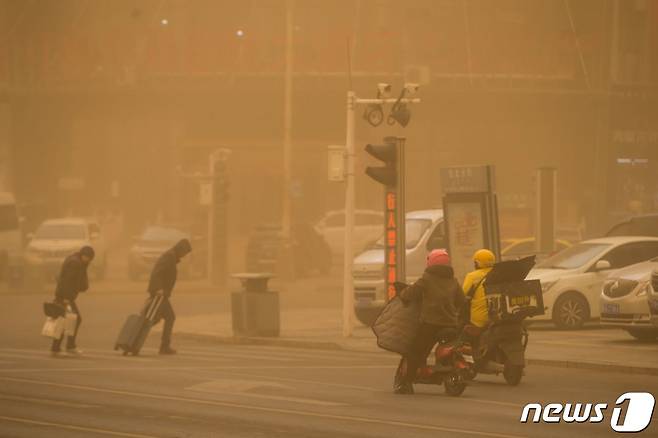 27일 중국 북부 내몽골 자치구 얼롄하오터의 거리에서 주민들이 짙은 황사 속을 통행하고 있다. 2024.03.27.ⓒ AFP=뉴스1 ⓒ News1 우동명 기자