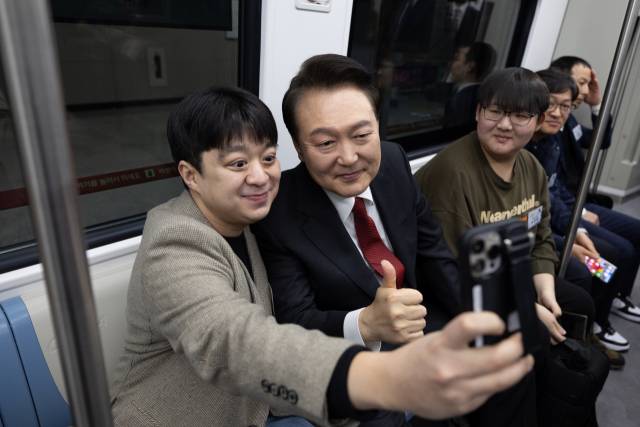 ▲윤석열 대통령이 29일 서울 강남구 수서역에서 수도권광역급행철도(GTX) A노선 수서~동탄 구간 개통 기념식을 마친 뒤 GTX A노선 열차에 시승해 함께 열차에 탑승한 시민들과 기념촬영을 하고 있다. ⓒ연합뉴스