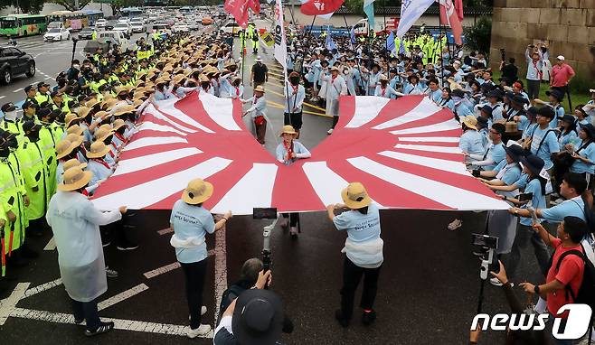 지난해 전국민중행동 통일선봉대 회원들이 서울 종로구 일본대사관 앞에서 ‘핵 오염수 해양투기 반대, 일본대사관 항의 행진’을 마치며 욱일기를 찢는 상징의식을 하고 있다. ⓒ News1 박세연 기자