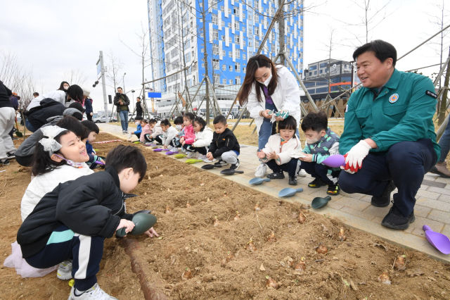 임병택 시흥시장(오른쪽)이 '시화호 30주년 나무 심기' 행사에서 아이들과 함께 식물을 심고 있다./사진제공=시흥시