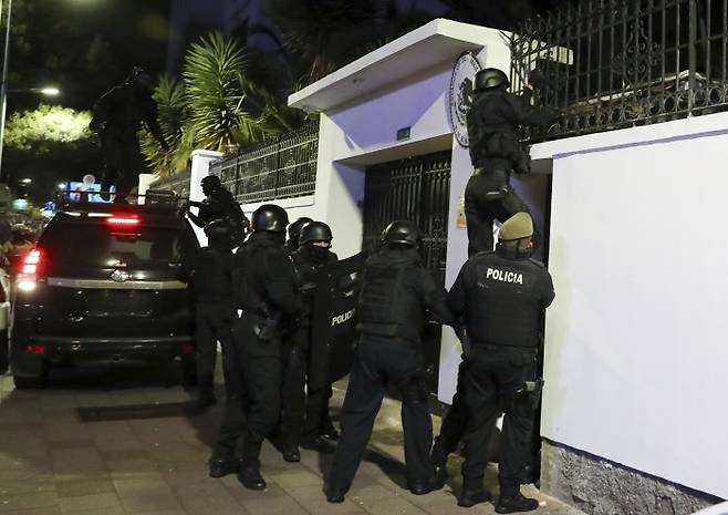 에콰도르 경찰이 지난 5일(현지시간) 지난해 말 키토 주재 멕시코 대사관으로 망명해 머물고 있는 호르헤 글라스 전 부통령을 체포하기 위해 대사관 담을 넘고 있다. AP연합뉴스