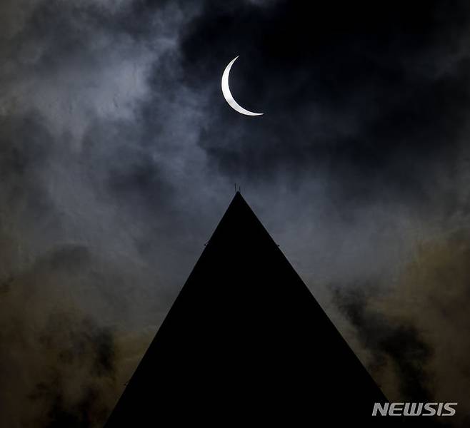 [워싱턴=AP/뉴시스] 8일(현지시각) 미 워싱턴DC의 워싱턴 기념비 상공에서 달이 태양을 완전히 가리는 개기일식이 진행되고 있다. 2024.04.09.