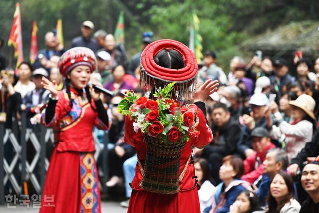 장강삼협 크루즈 삼협인가 투어에서 꽃 광주리를 등에 진 투자족 여인들이 전통혼례를 재현하고 있다.