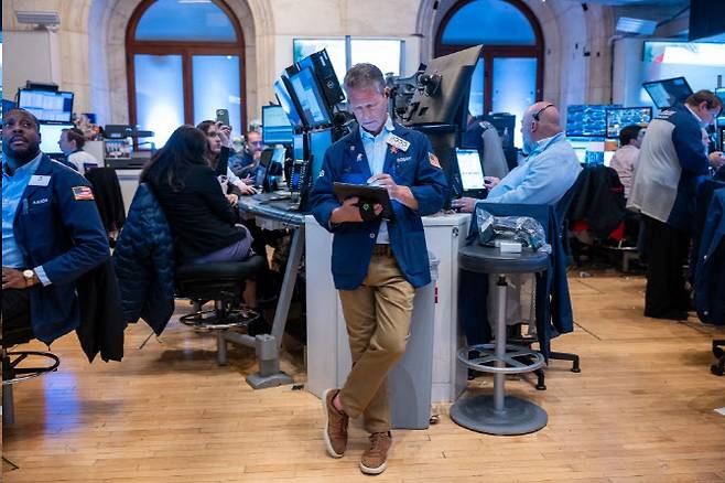 뉴욕증권거래소에서 트레이더가 다리를 꼬고 태블릿을 보고 있다. (사진=AFP)