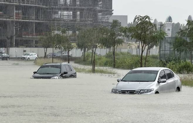 폭우가 쏟아진 16일 두바이 시내에서 차량들이 침수된 도로 위를 지나고 있다. (사진=로이터 연합뉴스)