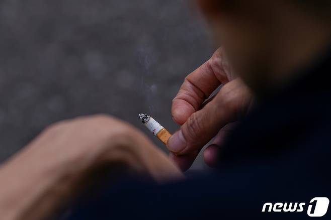 영국 런던에서 한 남성이 담배를 손에 들고 있다. 2023.04.11/뉴스1 ⓒ 로이터=뉴스1 ⓒ News1 김민수 기자