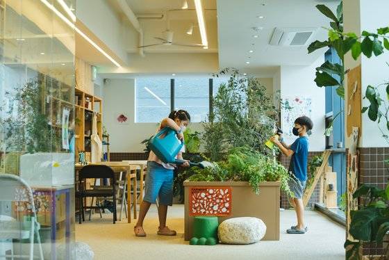 라이브러리 티티섬 9층에 마련된 실내 정원에서 청소년들이 식물에 물을 주고 있다. 사진 라이브러리 티티섬