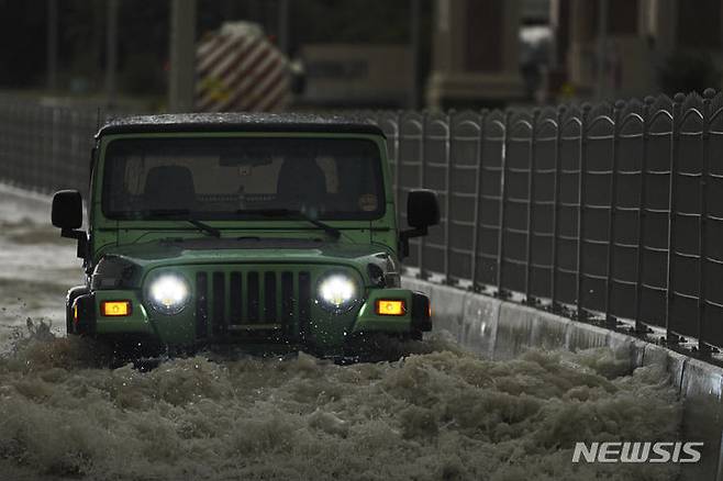 [두바이=AP/뉴시스]16일(현지시각) 하루 동안 2년 치의 폭우가 내린 두바이에서 한 SUV 차량이 물에 잠긴 도로를 지나고 있다. 2024.4.17.