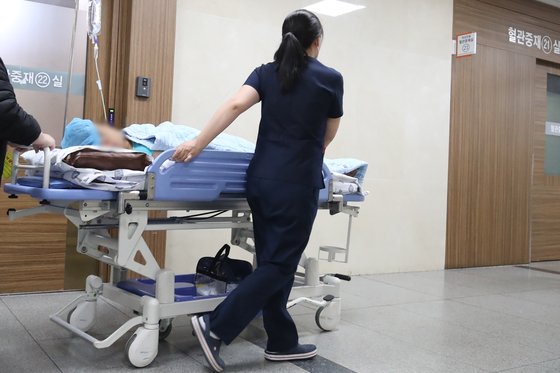 의대 증원을 둘러싼 의정갈등이 계속되는 가운데 8일 대구의 한 대학병원에서 간호사가 환자를 태운 침상을 옮기고 있다. 뉴스1