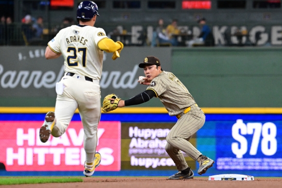 BASEBALL-MLB-MIL-SD/ - Apr 17, 2024; Milwaukee, Wisconsin, USA; San Diego Padres shortstop Ha-seong Kim (7) completes a double play after forcing out Milwaukee Brewers shortstop Willy Adames (27) in the first inning at American Family Field. Mandatory Credit: Benny Sieu-USA TODAY Sports