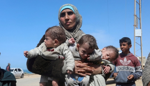 지난 3월 21일 이스라엘 공습을 피해 팔레스타인의 한 여성이 세 자녀와 함께 가자지구 중부에서 남쪽으로 이동하고 있다. 로이터 연합뉴스