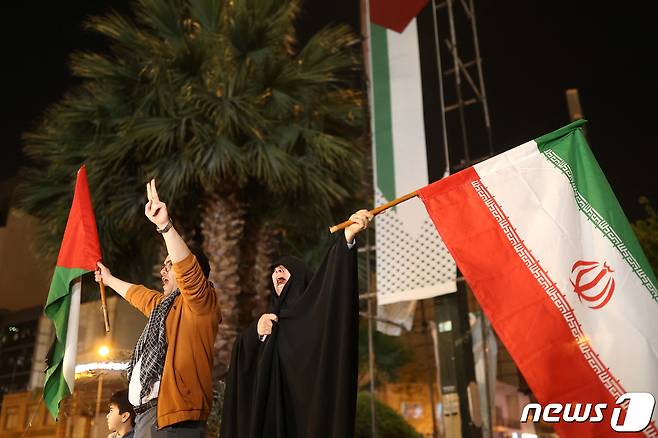 14일(현지시간) 이란이 이스라엘에 공습을 가한 이후 테헤란에서 이란인들이 거리로 나와 팔레스타인과 이란 국기를 흔들고 있다. 2024.04.14 ⓒ 로이터=뉴스1 ⓒ News1 정지윤 기자