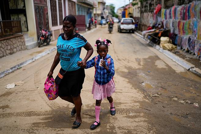 17일 아이티에서 한 아이가 보호자와 길을 걷고 있다./AP 연합뉴스