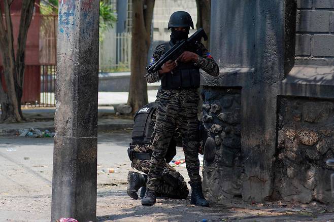 지난 8일 아이티 수도 포르토프랭스에서 한 무장 경찰이 총을 들고 거리에 서 있다./AFP 연합뉴스