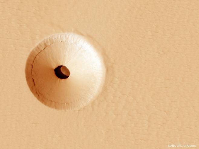 화성의 성 파보니스 화산(Pavonis Mons) 경사면에서 발견된 구멍. 용암 동굴로 들어가는 입구이다./NASA