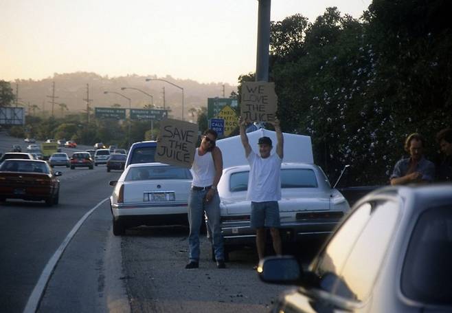 OJ심슨과 경찰의 추격전이 벌어지는 고속도로 길가에 OJ심슨을 응원하는 피켓을 든 채 서 있는 시민 <출처=Gettyimage>