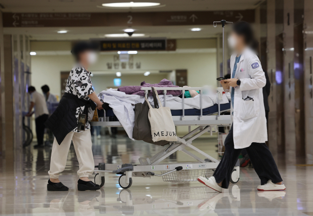 의대 정원 증원 정책과 관련해 의정 갈등이 두달 이상 이어지고 있는 19일 서울 시내 한 대학병원에서 의료 관계자와 환자들이 이동하고 있다. 연합뉴스
