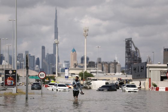 폭우로 물에 잠긴 두바이 도로 위를 한 시민이 걸어가고 있다. 로이터=연합뉴스